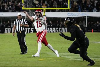 Utah quarterback Luke Bottari (15) throws a pass as he is pressured by Central Florida defensive end Daylan Dotson, right, during the first half of an NCAA college football game, Friday, Nov. 29, 2024, in Orlando, Fla. (AP Photo/John Raoux)