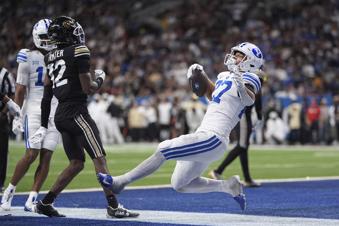 BYU running back LJ Martin (27) scores a touchdown in front of Colorado wide receiver Travis Hunter (12) during the second half of the Alamo Bowl NCAA college football game, Saturday, Dec. 28, 2024, in San Antonio. (AP Photo/Eric Gay)