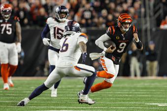 Cincinnati Bengals quarterback Joe Burrow (9) tries to get past Denver Broncos safety P.J. Locke (6) during the second half of an NFL football game in Cincinnati, Saturday, Dec. 28, 2024. (AP Photo/Jeff Dean)