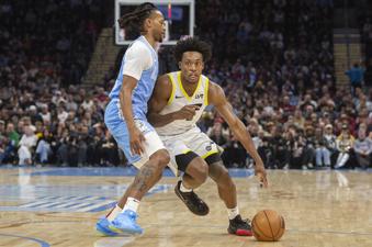 Cleveland Cavaliers' Darius Garland, left, defends as Utah Jazz Collin Sexton drives during the first half of an NBA basketball game in Cleveland, Monday, Dec. 23, 2024. (AP Photo/Phil Long)