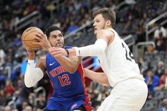 Detroit Pistons forward Tobias Harris (12) is defended by Utah Jazz center Walker Kessler (24) during the first half of an NBA basketball game, Thursday, Dec. 19, 2024, in Detroit. (AP Photo/Carlos Osorio)