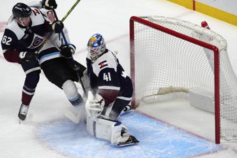 Colorado Avalanche left wing Artturi Lehkonen, left, blocks Utah Hockey Club right wing Dylan Guenther as his shot flies past Colorado goaltender Scott Wedgewood for a goal in the first period of an NHL hockey game Thursday, Dec. 12, 2024, in Denver. (AP Photo/David Zalubowski)