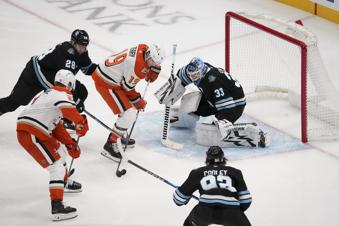 Anaheim Ducks right wing Troy Terry (19) shoots as defenseman Jackson LaCombe (2) assists while Utah Hockey Club goaltender Jaxson Stauber (33) defends with defenseman Ian Cole (28) and center Logan Cooley (92) during the second period of an NHL hockey game, Sunday, Dec. 22, 2024, in Salt Lake City. (AP Photo/Bethany Baker)
