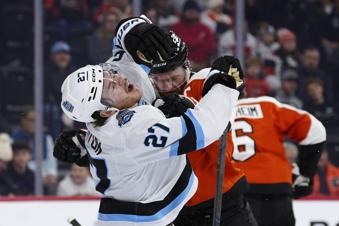 Utah Hockey Club's Barrett Hayton (27) is shoved by Philadelphia Flyers' Sean Couturier, center right, after a play during the first period of an NHL hockey game, Sunday, Dec. 8, 2024, in Philadelphia. (AP Photo/Derik Hamilton)