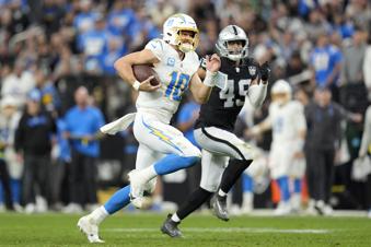 Los Angeles Chargers quarterback Justin Herbert (10) runs against Las Vegas Raiders defensive end Charles Snowden (49) during the second half of an NFL football game in Las Vegas, Sunday, Jan. 5, 2025. (AP Photo/Abbie Parr)