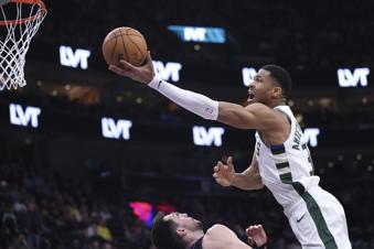 Milwaukee Bucks forward Giannis Antetokounmpo, right, goes to the basket against the Utah Jazz during the first quarter of an NBA basketball game, Monday, Jan. 27, 2025, in Salt Lake City. (AP Photo/Rob Gray)