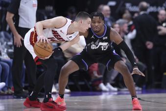 Miami Heat guard Tyler Herro (14) holds the ball away from Utah Jazz guard Isaiah Collier (13) during the second half of an NBA basketball game, Thursday, Jan. 9, 2025, in Salt Lake City. (AP Photo/Rob Gray)