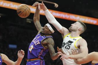 Phoenix Suns guard Bradley Beal (3) battles with Utah Jazz center Micah Potter (25) for a rebound during the first half of an NBA basketball game Saturday, Jan. 11, 2025, in Phoenix. (AP Photo/Ross D. Franklin)