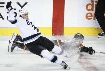 Utah Hockey Club's Michael Kesselring, left, checks Calgary Flames' Blake Coleman during the second period of an NHL hockey game in Calgary, Alberta, Thursday, Jan. 2, 2025. (Jeff McIntosh/The Canadian Press via AP)