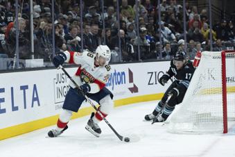 Florida Panthers defenseman Nate Schmidt (88) moves the puck against Utah Hockey Club center Nick Bjugstad (17) during the first period of an NHL hockey game, Wednesday, Jan. 8, 2025, in Salt Lake City. (AP Photo/Melissa Majchrzak)
