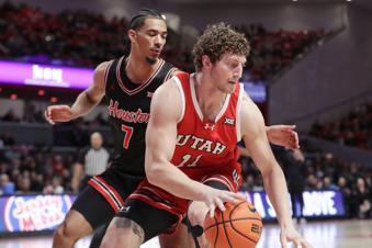Utah forward Caleb Lohner (11) attempts to drive around Houston guard Milos Uzan (7) during the first half of an NCAA college basketball game, Wednesday, Jan. 22, 2025, in Houston. (AP Photo/Michael Wyke)