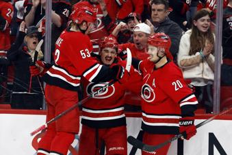 Carolina Hurricanes' Seth Jarvis, center, celebrates his goal with teammates Jackson Blake (53) and Sebastian Aho (20) during the second period of an NHL hockey game against the Utah Hockey Club in Raleigh, N.C., Saturday, Feb. 8, 2025. (AP Photo/Karl DeBlaker)