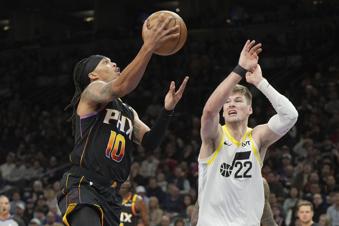 Phoenix Suns guard Damion Lee (10) drives against Utah Jazz forward Kyle Filipowski (22) during the first half of an NBA basketball game, Friday, Feb. 7, 2025, in Phoenix. (AP Photo/Rick Scuteri)