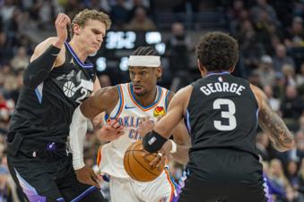 Oklahoma City Thunder guard Shai Gilgeous-Alexander, middle, dribbles between Utah Jazz forward Lauri Markkanen, left, and Utah Jazz guard Keyonte George (3), during the first half of an NBA basketball game Friday, Feb. 21, 2025, in Salt Lake City. (AP Photo/Rick Egan)