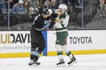 Utah Hockey Club center Jack McBain (22) fights with Minnesota Wild defenseman Jake Middleton (5) during the first period of an NHL hockey game, Thursday, Feb. 27, 2025, in Salt Lake City. (AP Photo/Melissa Majchrzak)