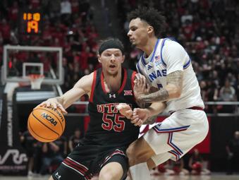 Utah guard Gabe Madsen (55) dribbles around Kansas guard Zeke Mayo (5) during the second half of an NCAA college basketball game, Saturday, Feb. 15, 2025, in Salt Lake City. (AP Photo/Bethany Baker)