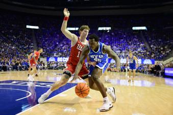BYU center Fousseyni Traore (45) drives to the basket guarded by Utah forward Caleb Lohner (11) during the first half of an NCAA basketball game Saturday, March 8, 2025, in Provo, Utah. (AP Photo/Tyler Tate)