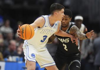 BYU guard Egor Demin, left, looks to pass the ball as Virginia Commonwealth guard Zeb Jackson defends during the first half in the first round of the NCAA college basketball tournament Thursday, March 20, 2025, in Denver. (AP Photo/David Zalubowski)