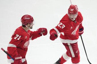Detroit Red Wings left wing Lucas Raymond (23) celebrates his goal with Dylan Larkin (71) in the third period of an NHL hockey game against the Minnesota Wild, Saturday, Feb. 22, 2025, in Detroit. (AP Photo/Paul Sancya)