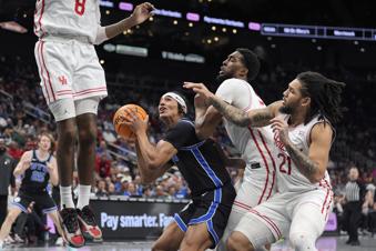 Brigham Young's Trey Stewart looks to the basket as Houston's Mylik Wilson (8), Ja'Vier Francis, second from right, and Emanuel Sharp (21) defend during the first half of an NCAA college basketball game in the semifinal round of the Big 12 Conference tournament, Friday, March 14, 2025, in Kansas City, Mo. (AP Photo/Charlie Riedel)