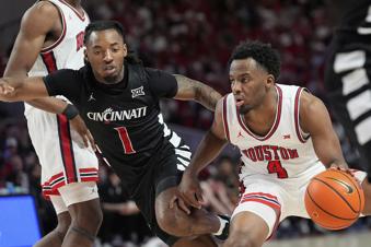 Houston's L.J. Cryer (4) keeps the ball from Cincinnati's Day Day Thomas (1) during the second half of an NCAA college basketball game Saturday, March 1, 2025, in Houston. (AP Photo/David J. Phillip)