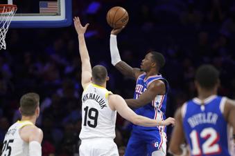 Philadelphia 76ers' Lonnie Walker IV, right, goes up for a shot against Utah Jazz's Svi Mykhailiuk during the second half of an NBA basketball game Sunday, March 9, 2025, in Philadelphia. (AP Photo/Matt Slocum)