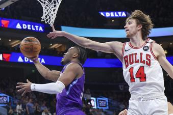 Utah Jazz guard Isaiah Collier, left, lays the ball up against Chicago Bulls forward Matas Buzelis (14) during the first half of an NBA basketball game, Monday, March 17, 2025, in Salt Lake City. (AP Photo/Rob Gray)