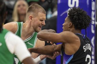 Boston Celtics center Kristaps Porzingis, left, and Utah Jazz guard Collin Sexton, right, get into a shoving match during the second half of an NBA basketball game Friday, March 21, 2025, in Salt Lake City. (AP Photo/Rick Egan)
