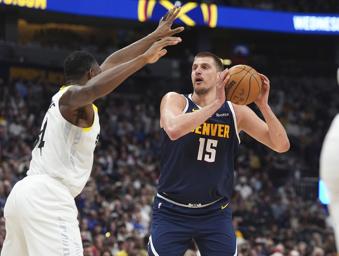 Denver Nuggets center Nikola Jokic, right, goes up for a basket as Utah Jazz center Oscar Tshiebwe, left, defends in the first half of an NBA basketball game Friday, March 28, 2025, in Denver. (AP Photo/David Zalubowski)