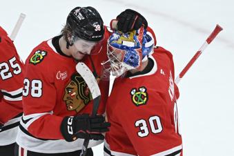 Chicago Blackhawks goalie Spencer Knight (30) celebrates with teammate Ethan Del Mastro (38) after defeating the Los Angeles Kings in an NHL hockey game Monday, March 3, 2025, in Chicago. (AP Photo/Paul Beaty)