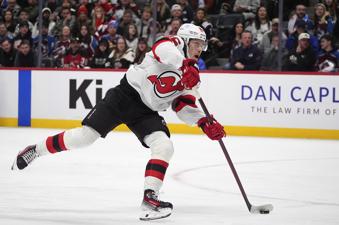 FILE - New Jersey Devils center Jack Hughes shoots the puck during an NHL hockey game, Feb. 26, 2025, in Denver. (AP Photo/David Zalubowski, File)