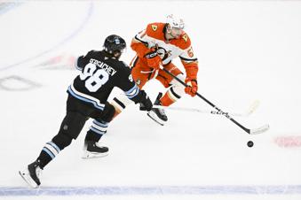 Utah Hockey Club defenseman Mikhail Sergachev (98) and Anaheim Ducks left wing Cutter Gauthier (61) battle for the puck during the first period of an NHL hockey game, Wednesday, March 12, 2025, in Salt Lake City. (AP Photo/Alex Goodlett)