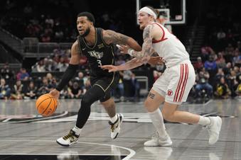 UCF's Darius Johnson (3) drives to the basket past Utah's Gabe Madsen during the first half of an NCAA college basketball game in the first round of the Big 12 Conference tournament, Tuesday, March 11, 2025, in Kansas City, Mo. (AP Photo/Charlie Riedel)