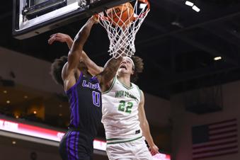 Grand Canyon guard Ray Harrison (0) dunks the ball under pressure from Utah Valley forward Carter Welling (22) during the first half of an NCAA college basketball game in the championship of the Western Athletic Conference tournament Saturday, March 15, 2025, in Las Vegas. (AP Photo/Chase Stevens)